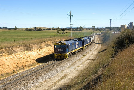 一列火车在工业综合体与主线之间的一条上行驶运输车树主要的图片