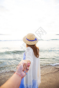 独自的美丽年轻女孩牵着一个男人的手看着大海美丽的年轻女孩牵着一个男人的手看着大海假期一种图片