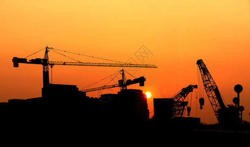 重的日落时Silhouette起重机建筑大楼脚手架城市的图片