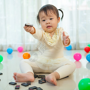 小可爱的亚洲女孩在家里和黑多米诺玩人类快乐的房间图片