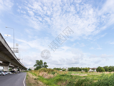 通向城市的高速公路桥该城市在镇边缘附近的大片田地中途车建造风景优美图片