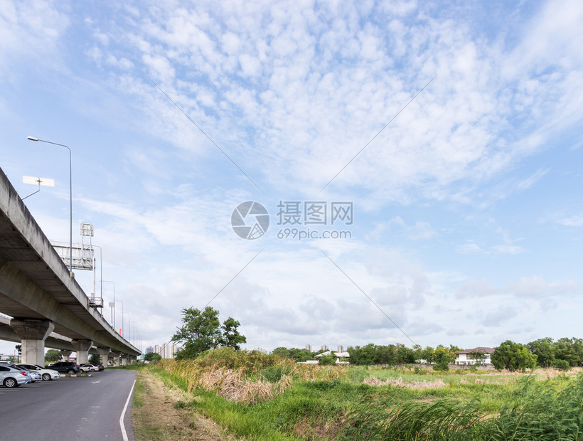 通向城市的高速公路桥该城市在镇边缘附近的大片田地中途车建造风景优美图片