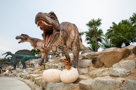场景自然公园石头上的巨型棕色恐龙雕像侏罗纪图片