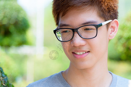 幸福英俊的近视穿着眼镜亚洲英俊少年男孩肖莱特欢快乐的时装男青年微笑与在泰国绿色自然背景公园的快乐在一起喜悦亚洲青少年男孩笑着图片