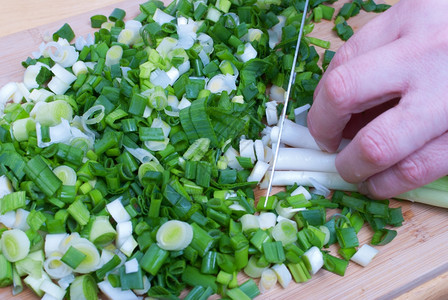 在厨房工作的女人切开蔬菜泉生洋葱用于沙拉关闭厨师切开洋葱准备锋利的刀图片
