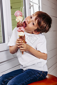 6岁时吃高冰淇淋甜筒的六勺巧克力香草和莓食物萨姆纳斯在室内图片