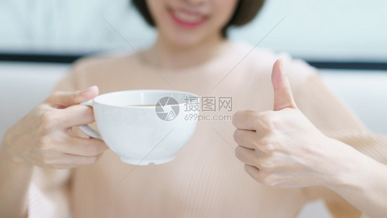 黑色的手好咖啡喝茶或早上喝白杯热饮酒的女子美丽图片