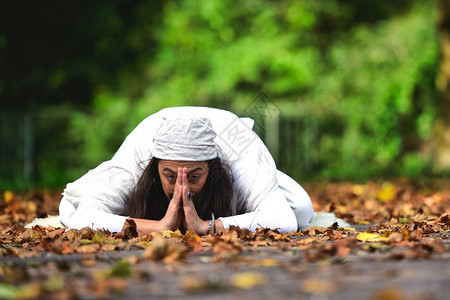 瑜伽姿势在公园秋天的落叶中东方浓度碗图片