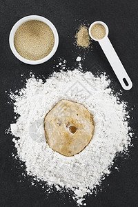 水准备面包或比萨烘烤的酵卷拍摄在面粉中发酵的选择焦点上拍下头部的照片关注面粉中的发酵母面团中间图片