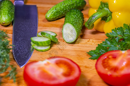 香菜白色的刀片和新鲜蔬菜胡椒黄瓜鹦鹉番茄把刀子和蔬菜放在剪切板上食物图片