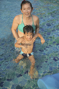 套装泰国母亲和儿子在水池中玩乐女士图片
