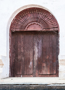 锁正面泰国寺庙入口的旧木制门头图片