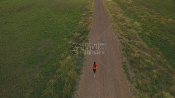 跑山区日落时妇女在农村公路上运行的空中景象夏天男人图片