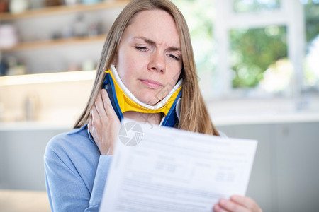 人类鞭打接受颈部伤害后在家阅读信件中的妇女不适图片