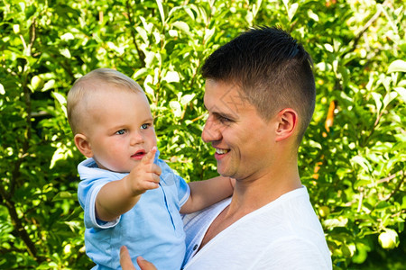 美丽婴儿男人迷的caucasian幼童父亲在花园里图片