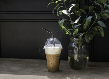日光木制桌边的冰奶咖啡库存照片金属树叶木头图片