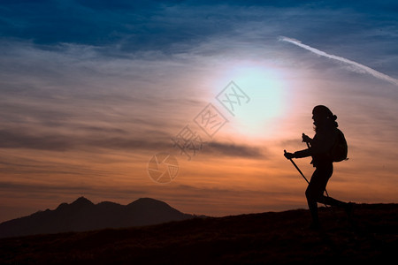 孤独运动快乐的妇女在日落外出探险活跃生方式山丘上徒步旅行图片