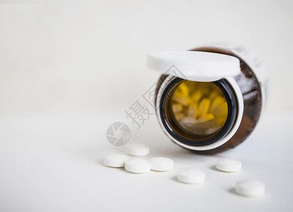 剂量棕色瓶子白背景溢出的圆药丸医疗的塑料图片