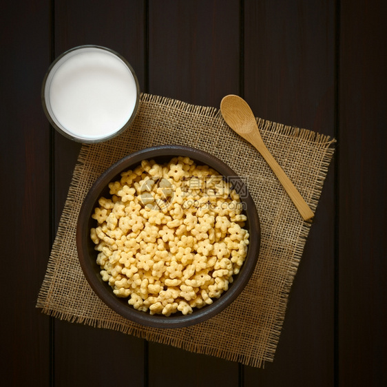 香味早餐在生锈的碗里吃麦片加牛奶杯和侧边木勺子用自然光照着黑木头星制的玻璃图片