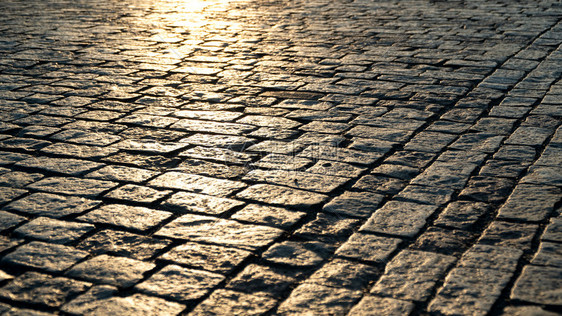 铺路有质感的在黎明时光照亮擦石像和阳光砖图片