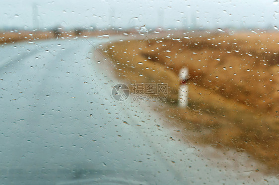 在大雨中驾车高速公路上汽车玻璃的雨滴湿沥青液体下雨抽象的图片