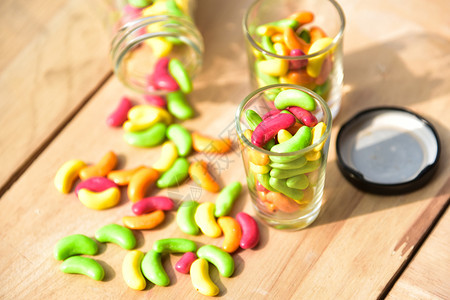 果酱甜的点一罐装满彩色糖果的玻璃罐放在木本底图片