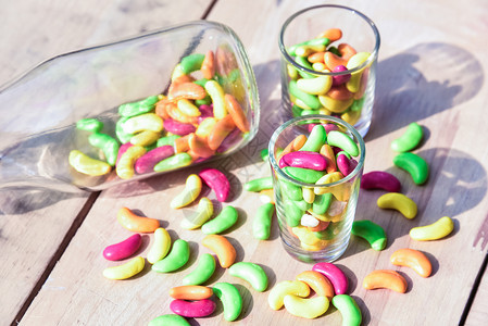 不良一罐装满彩色糖果的玻璃罐放在木本底什锦的品种图片