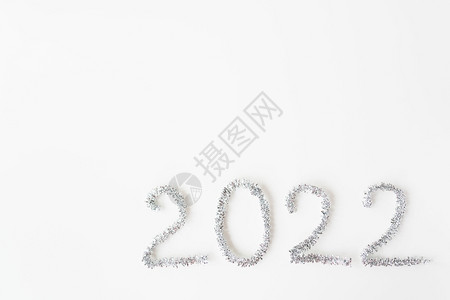 闪光20年新快乐用箔纸写新年雨在孤立的白色背景上新年快乐问候20年新快乐雨在孤立的白色背景上新年快乐问候时髦的金子图片