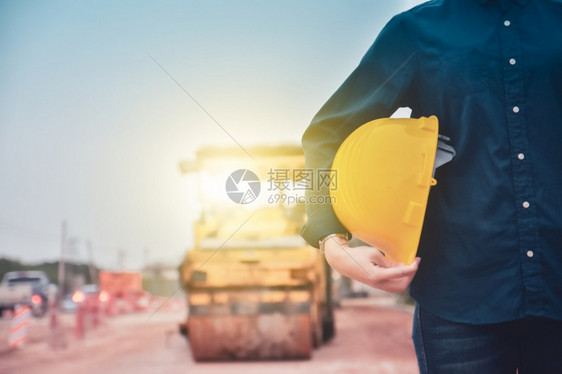 保持承包商工作紧贴身戴硬帽的工程师站在道路建筑背景上站立图片