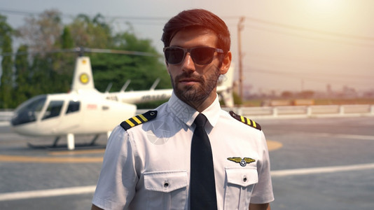 私人的男在小型私直升机附近站立着身穿制服的商业飞行员肖像生活图片
