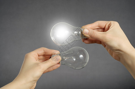 智力解决消耗手持两个灯泡其中一在发光手持两个灯泡其中之一正在发光图片