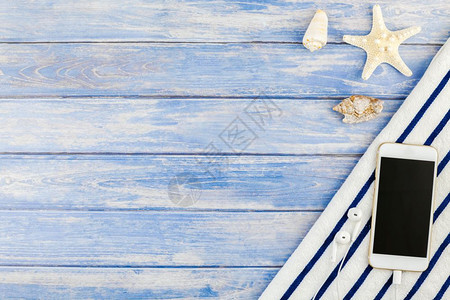 听筒夏天海滩毛巾智能手机贝壳海星的顶端视图其背景为面糊蓝木板底并附有空间模拟文本板复制件一海边毛巾小样图片