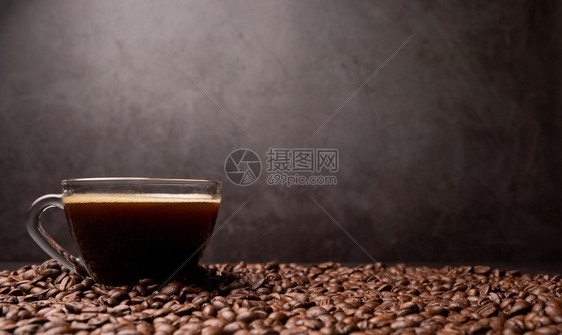 一个咖啡杯和组黑豆的侧面是背景粗黑色咖啡底部纹理以及咖啡底部有质感的美食黑暗图片
