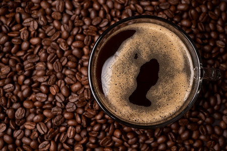 喝咖啡杯和黑豆组的顶端视图是背景粗黑色咖啡底部纹理咖啡底部杯子因图片