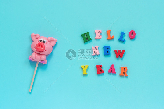 希望躺着有趣的粉红猪棒糖和多彩标志你好新年在蓝底背景的色新年风景最上观菜样贺卡猪棒冰蜜年短信新快乐粉色的图片
