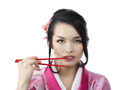 美丽的年轻日本女子肖像她有两对竹棍穿着白色背景的传统木子服饰白衣女郎筷子人类东方图片