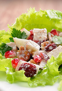 晒干吃鸡肉石榴红莓胡桃和奶酱生菜叶的沙拉牛奶图片