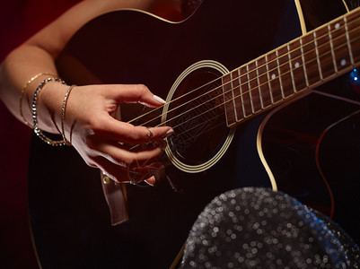 女声学品丝近一点女人弹吉他在背景上烟熏的舞台图片