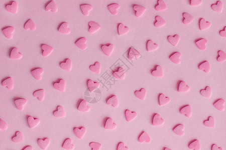 婚礼面包店时髦的粉红甜点在背景纹理上以心的形式喷洒图片