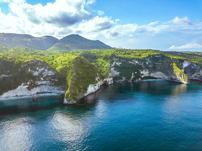 自然印度尼西亚一个长满丛林的热带大岛海洋的岩石岸蓝天上的云鸟瞰热带岛屿的岩石海岸和云彩鸟瞰图水洛基图片