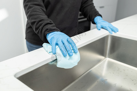 人类女士手握在保护套上清洁现代水槽用最起码的家厨房布清洗家务图片