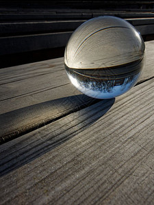 背景和纹理木制桌上的玻璃球折射内风景的一部分玻璃球折射光滑艺术形式图片
