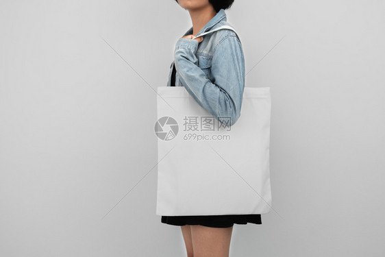 人们持有生态棉花袋的年轻女子在白色背景上孤立女士材料图片
