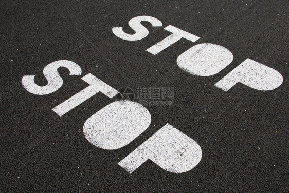 方向黑色的粒状在沥青路面的涂上停止标志图片