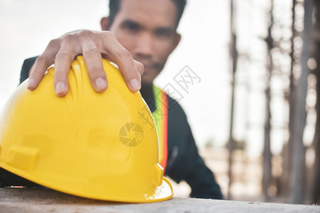 服务在工地建筑背景上紧贴手持硬帽的工人安全建筑学图片