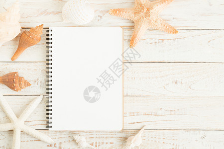 纸空的美丽白木地板上空白笔记本和贝壳图片