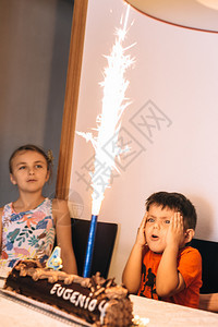 制作蜡烛可爱的孩子们庆祝生日和在室内自制烤蛋糕上看烟花节日的小孩图片