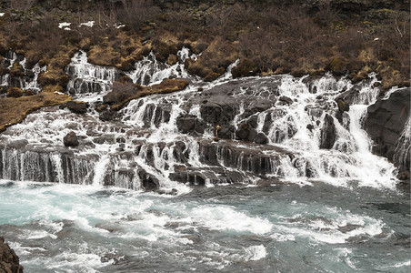 Hraunfossar瀑布冰地上含蓝水自然天色河图片