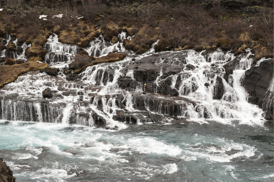 Hraunfossar瀑布冰地上含蓝水自然天色河图片