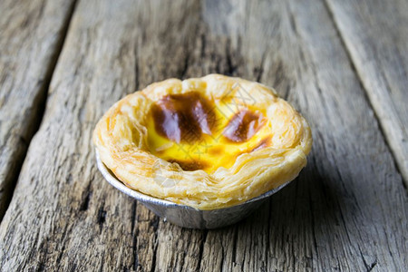 圆形的木头背景上美味的葡萄牙鸡蛋薄饼酸面包店图片